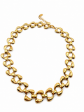 A chunky gold-tone chain necklace with oversized, rounded links, displayed on a clean white background.