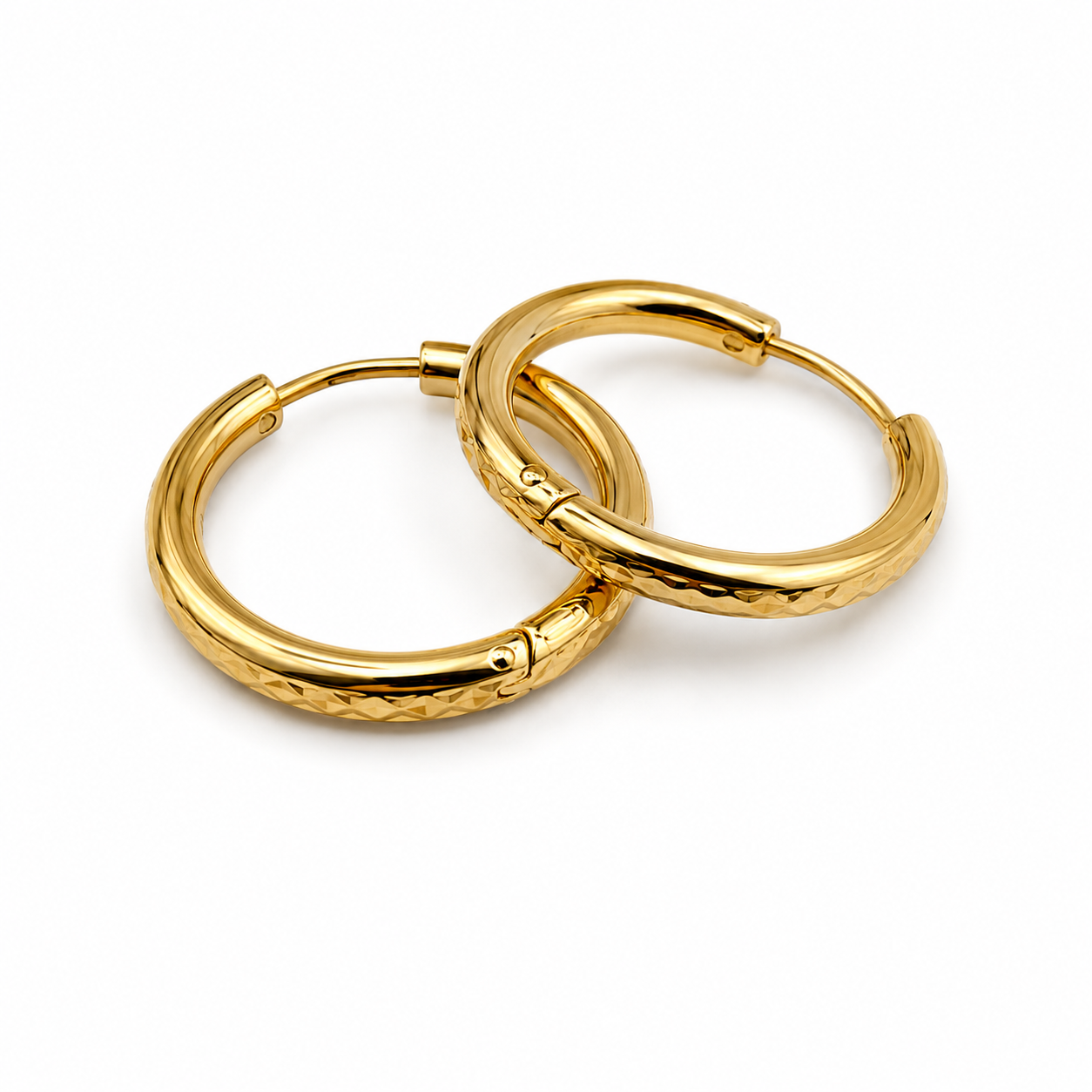 A pair of gold hoop earrings with a textured, diamond-patterned outer surface and a polished inner band, shown on a clean white background.