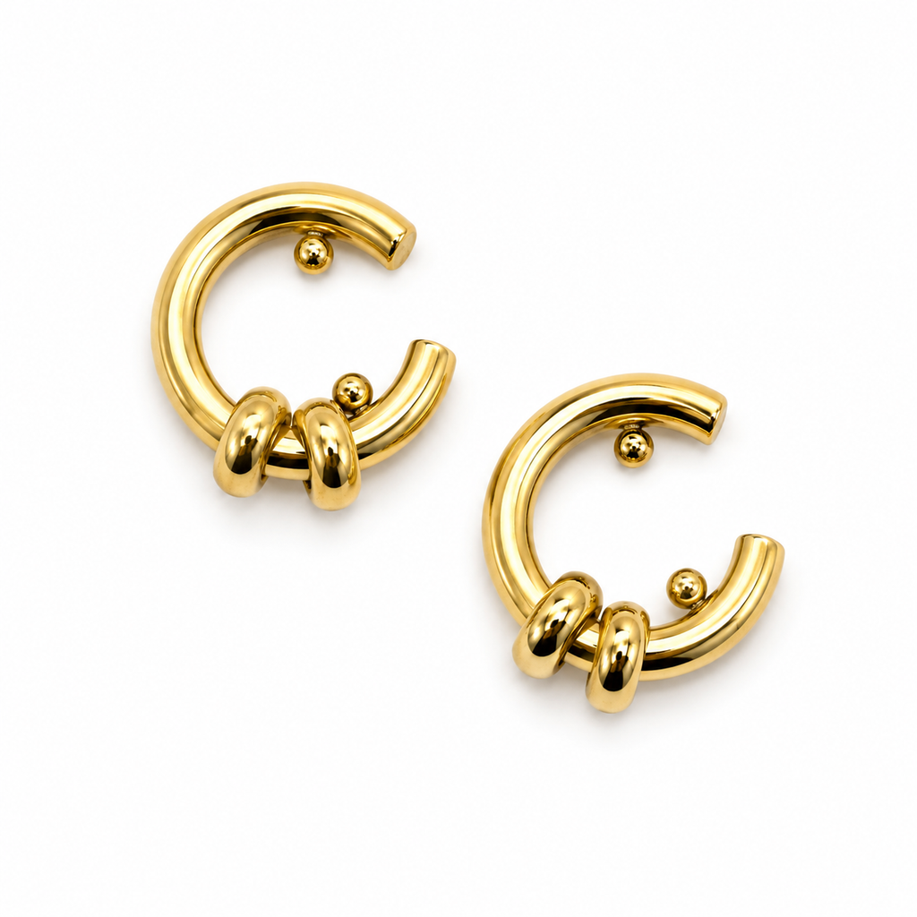 A pair of gold-plated C-shaped hoop earrings with three twisted barbell details on the front, shown on a clean white background.