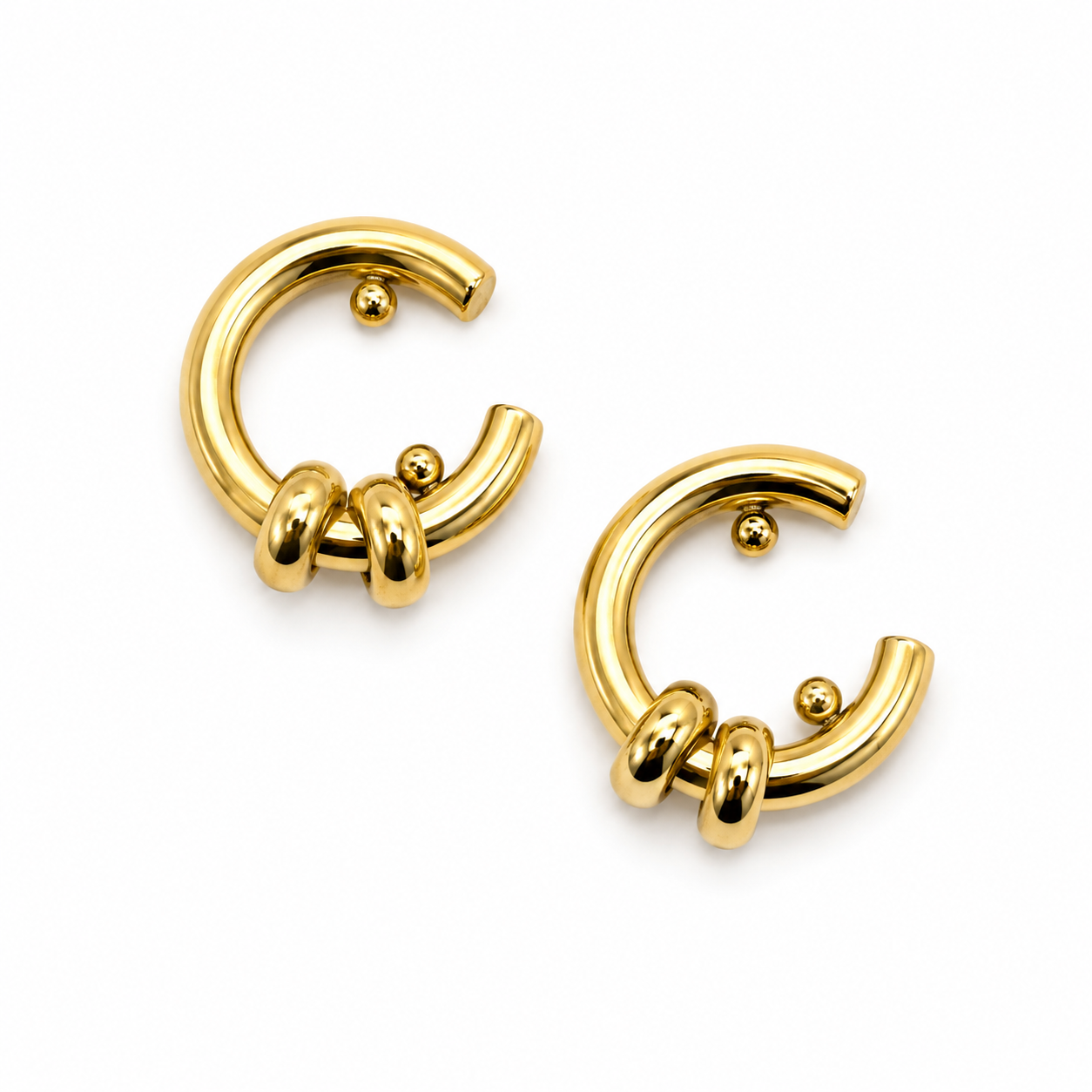 A pair of gold-plated C-shaped hoop earrings with three twisted barbell details on the front, shown on a clean white background.