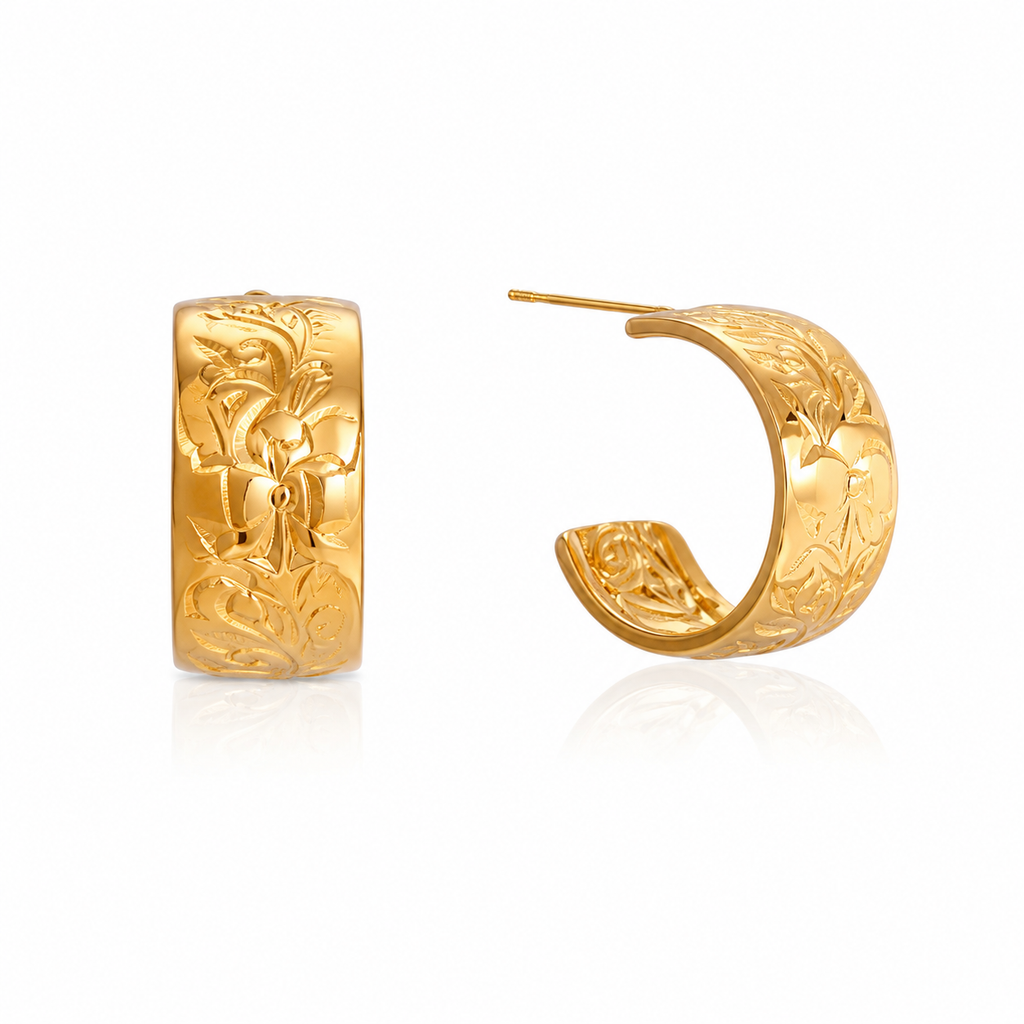 A pair of gold huggie hoop earrings with detailed floral engravings, shown from the front and side on a white background with a soft reflection.