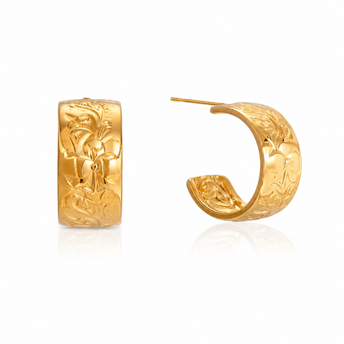 A pair of gold huggie hoop earrings with detailed floral engravings, shown from the front and side on a white background with a soft reflection.
